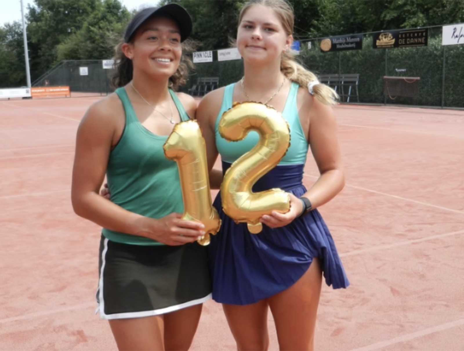 Two players celebrating twelve wins with number balloons